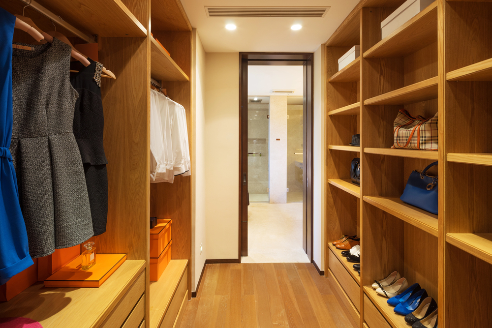 Luxury walk-in wardrobe with wood shelving, hanging space, drawers, and shoe storage featured in a closet dimensions guide